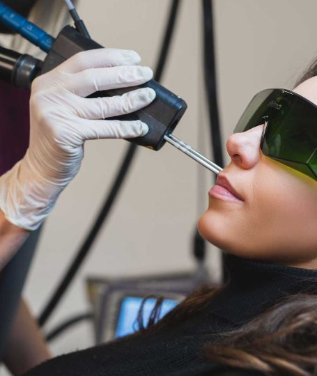 Γυναίκα σε θεραπεία αποτρίχωσης προσώπου με λέιζερ σε ιατρικό χώρο